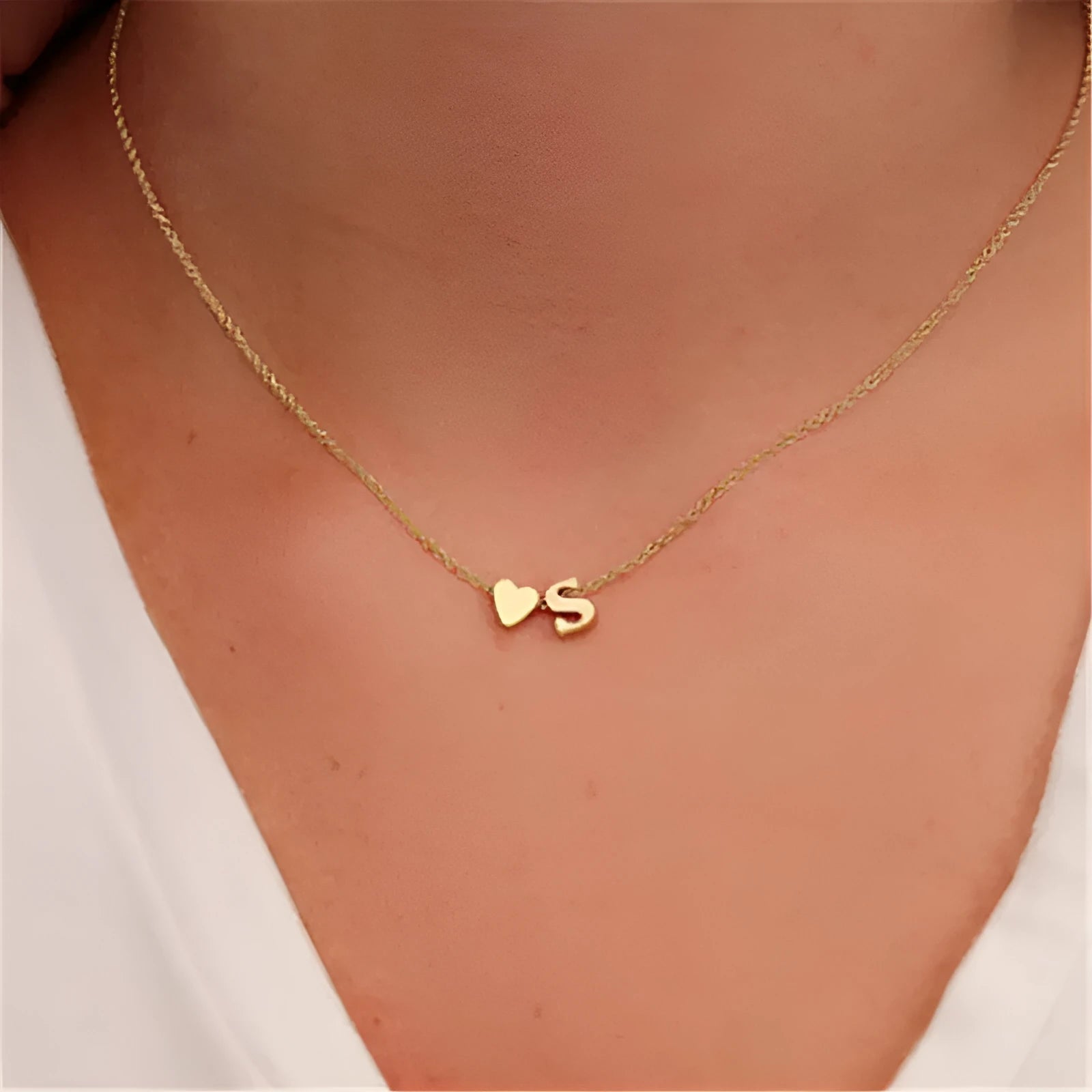 Gold alloy peach heart-shaped pendant featuring a single raised letter, shown from the front.