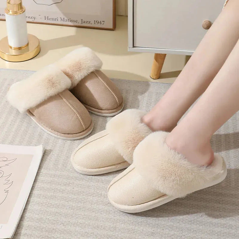 Brown plush indoor slippers for women with a non-slip PVC sole on a wooden floor.