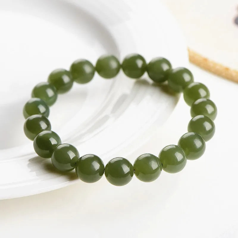 A polished Hetian jade bead bracelet in deep clear water colour on a wrist.