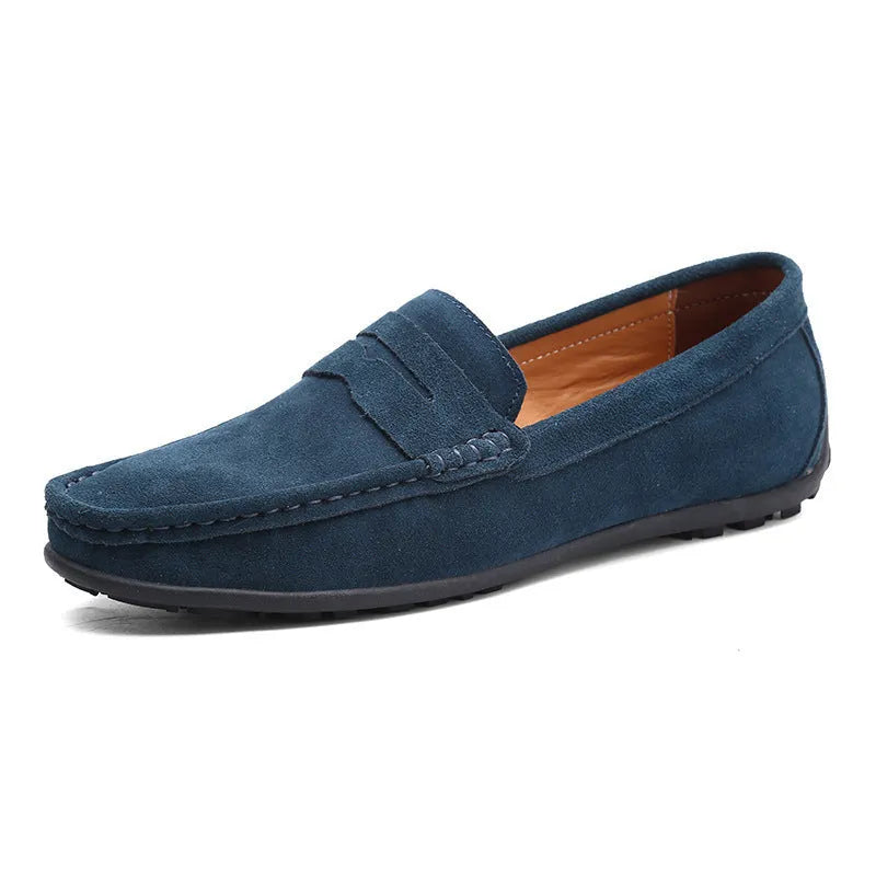 Men's suede leather Gommino loafers in black on a flat rubber sole, showing round toe and sewing line detail.