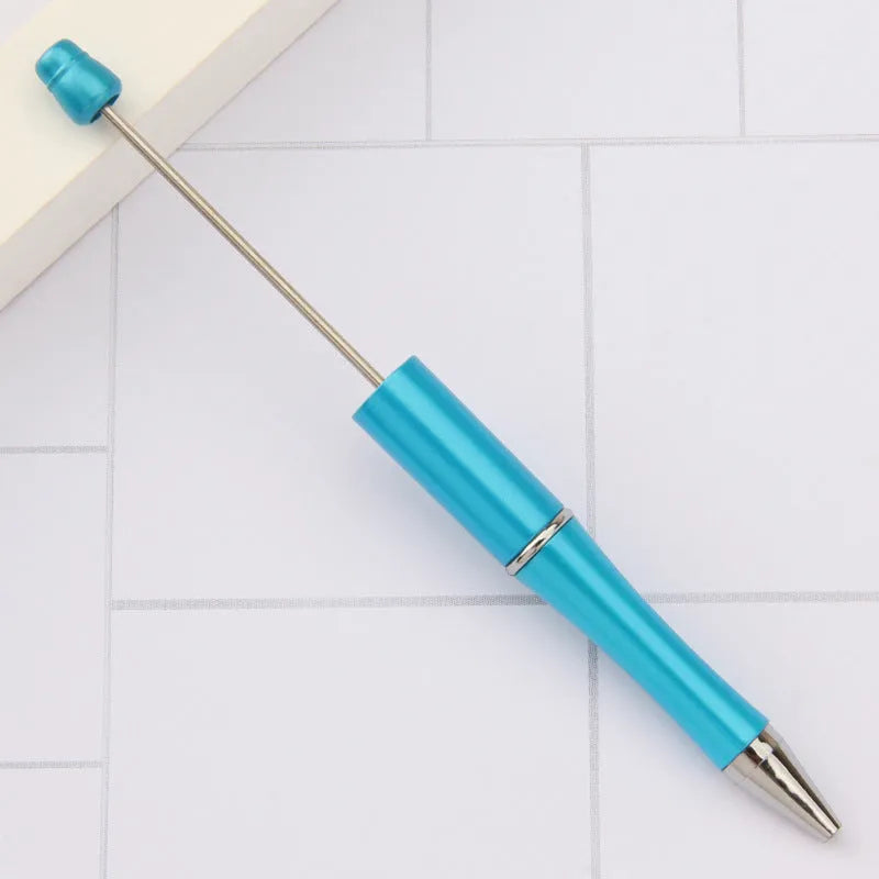 Colourful spinning ballpoint pen with plastic beads on a white background.