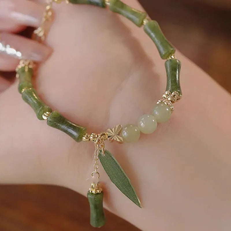 Chinese style glass bracelet with bamboo leaf design on wrist.