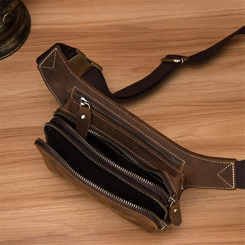 Brown top-grain cowhide men's sports waist bag with pull-cord closure, shown with a 10-inch laptop.
