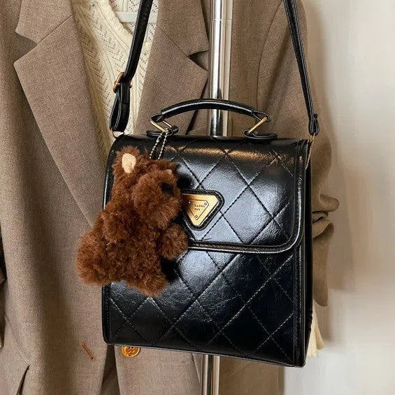Mini PU backpack in brown with polyester lining, phone pocket, stitching detail, and optional pendant