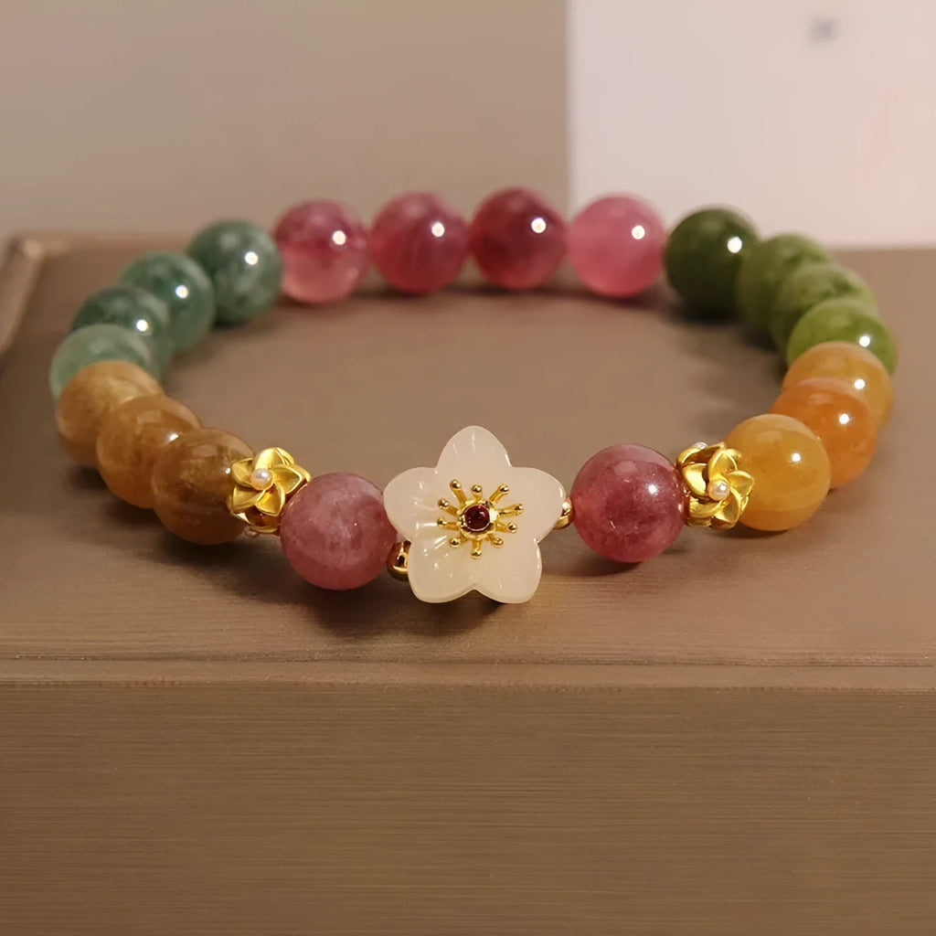 Natural colour tourmaline bracelet with silver electroplated flower and fu character charms on a geometric beaded band.