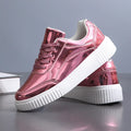 Gold sequinned platform sneakers with thick sole and round toe on a white background.