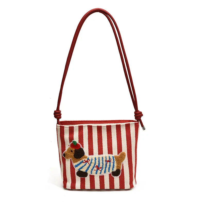 Cartoon sausage dog bucket bag in polyester with canvas lining, soft crossbody shape and single strap.