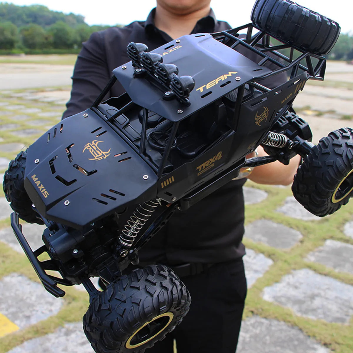 Large black 4WD off-road remote control car with 2.4G wireless controller on rough terrain