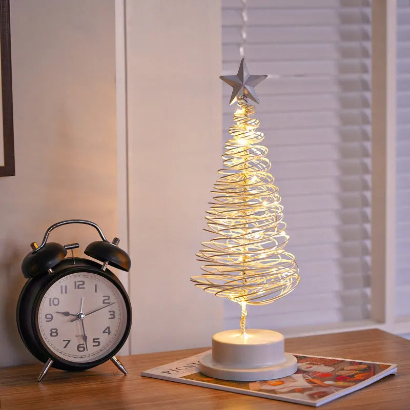 Wrought iron LED Christmas tree spiral light on a table, glowing warm white.