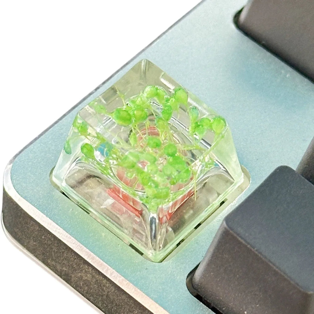 High transparency resin keycap with starry sky design in green, pink, red and violet colours.