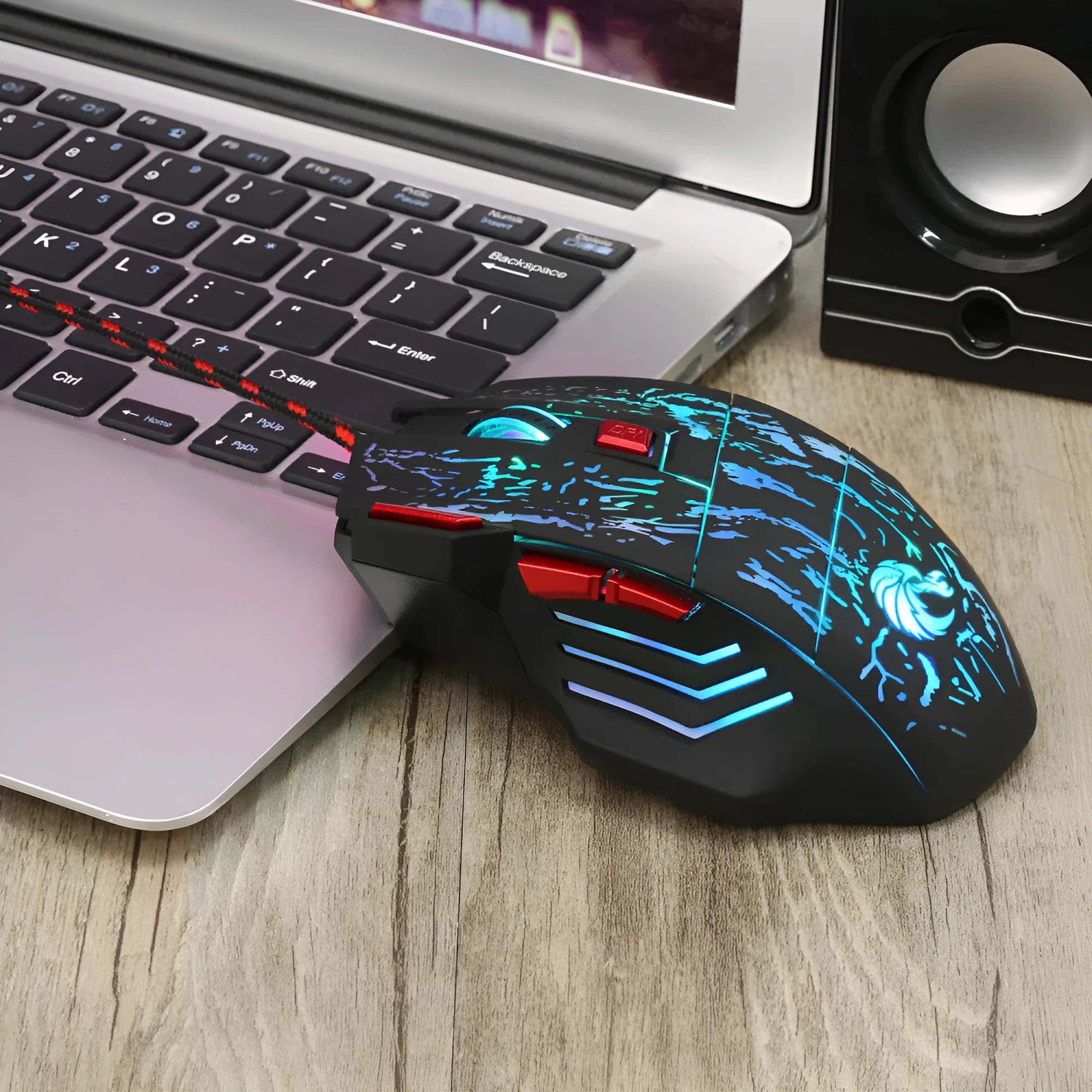 Black wired gaming mouse with colourful luminous lighting effects on desktop