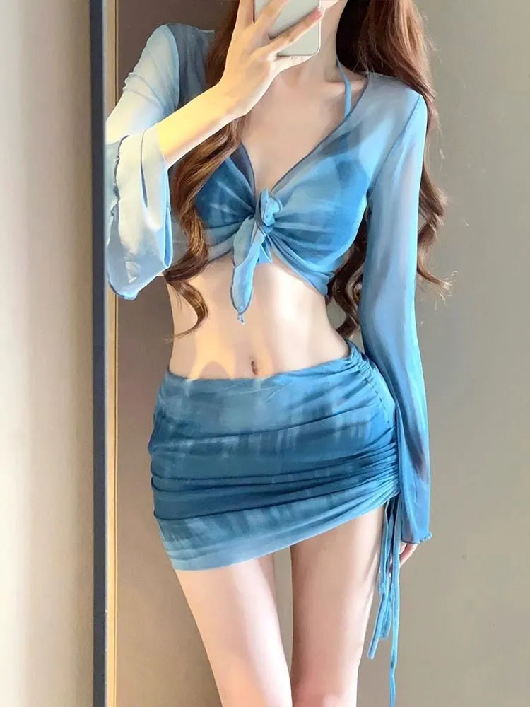 Blue women's high-waist bikini four-piece set showing shirt, bra, briefs, and skirt laid flat.