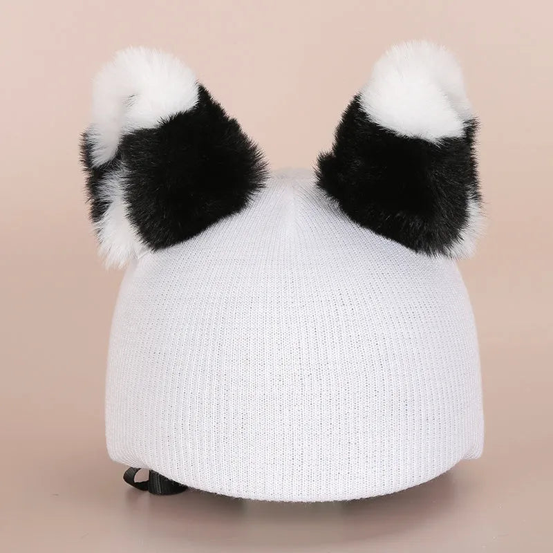 Plush cartoon character decoration sitting on top of a blue ski helmet for customisation.