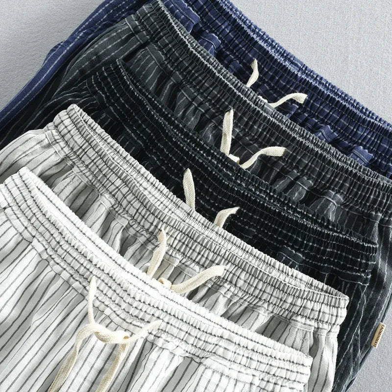 Man wearing black and white striped casual cotton shorts with a loose straight-leg fit.