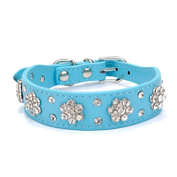 A black PU leather dog collar decorated with sparkling rhinestone flowers and metal studs, showing the adjustable eyelets and metal D-ring.