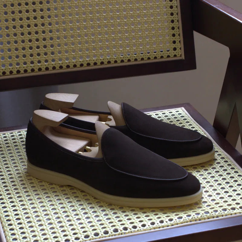 British handmade men's brown leather loafers with a flat TPR sole on a white background.