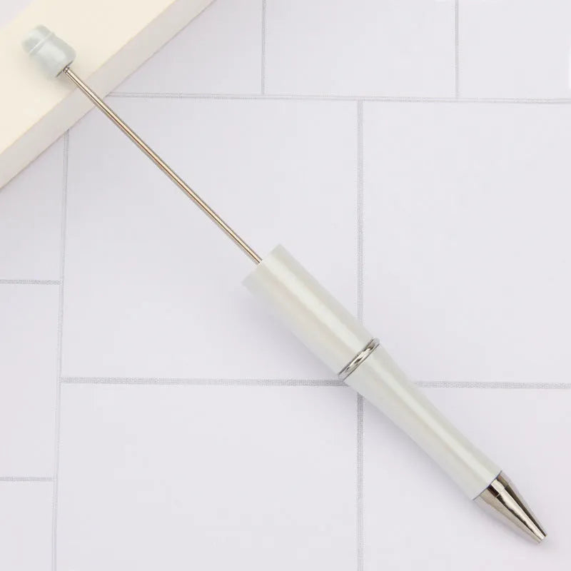 Colourful spinning ballpoint pen with plastic beads on a white background.