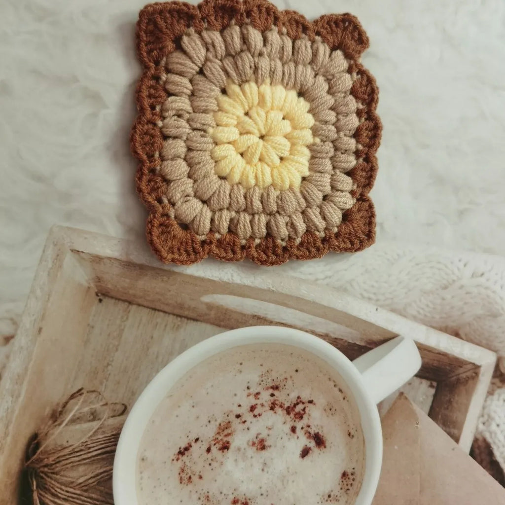 Hand crocheted wool cup coaster in Grandmother Lattice pattern, colour options include Emerald, Sea Salt Blue, Dream Purple, and Fog Brown.