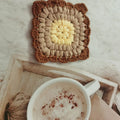Hand crocheted wool cup coaster in Grandmother Lattice pattern, colour options include Emerald, Sea Salt Blue, Dream Purple, and Fog Brown.