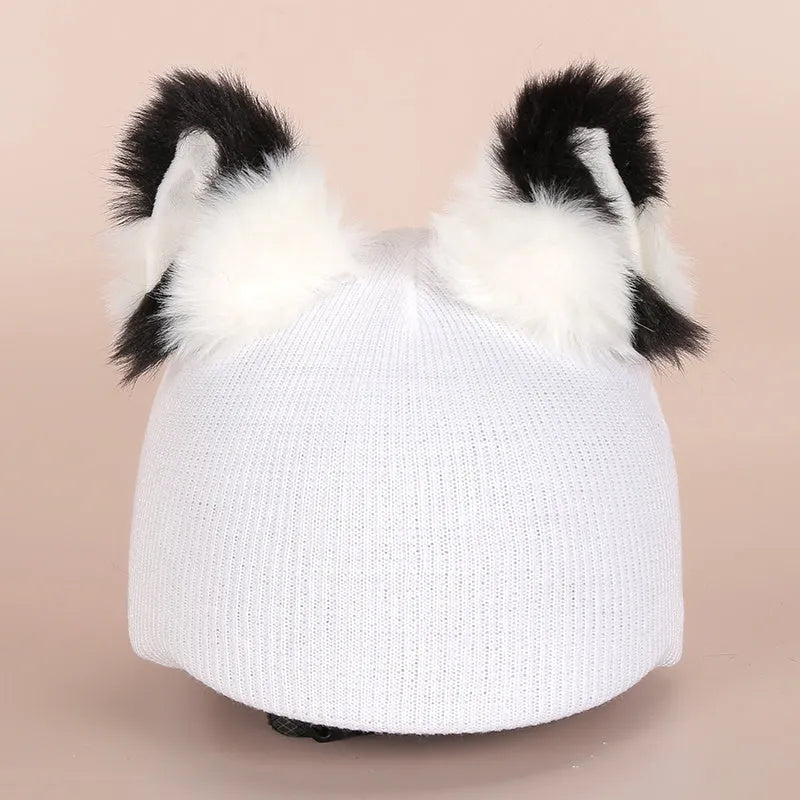 Colourful plush cartoon hat decoration sitting on top of a ski helmet