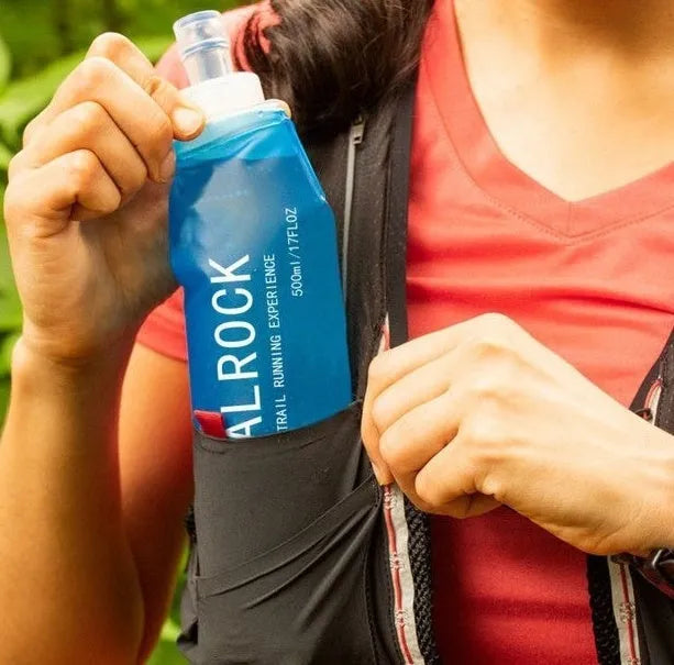 Close-up of a grey flexible plastic hydration straw with a textured grip and a blue silicone cap for mountain biking