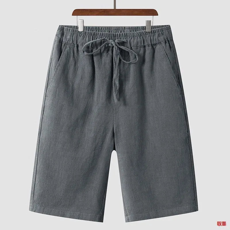 Man wearing beige linen loose-fit cropped shorts on a summer day.