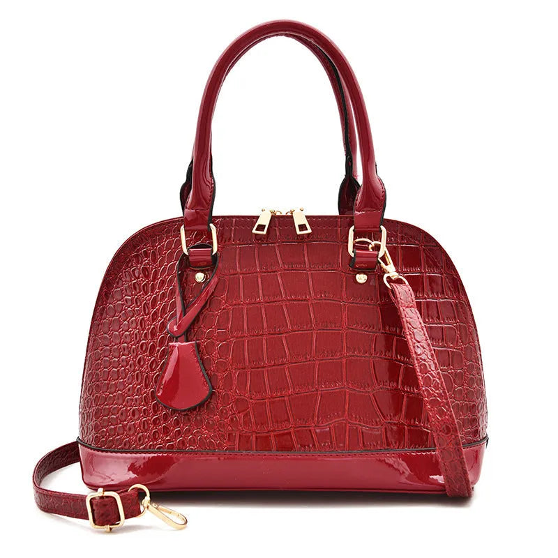 Large shiny black PU leather crossbody bag with shell-shaped design showing interior organisation.