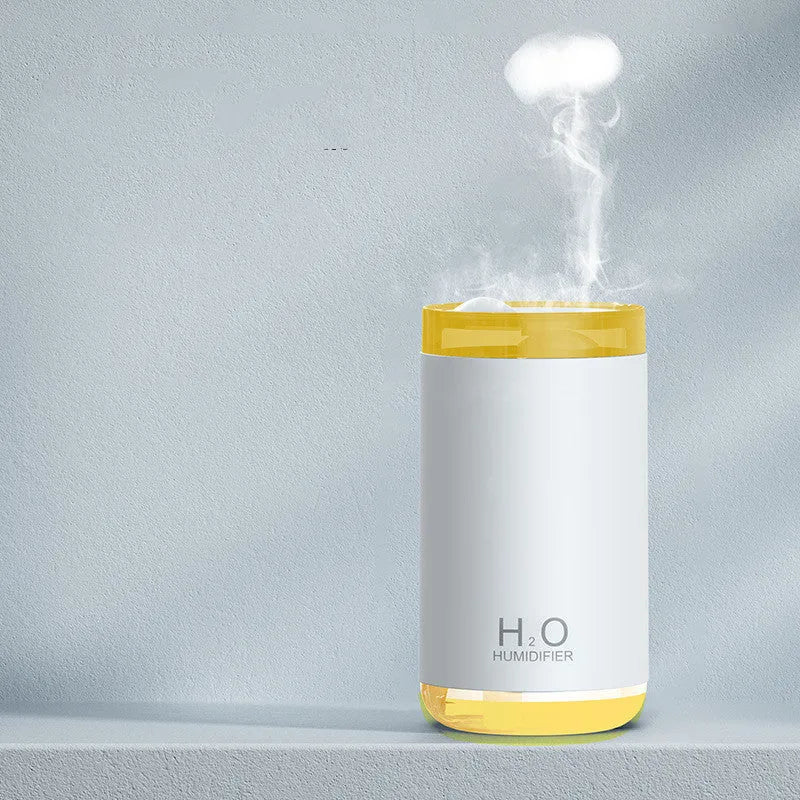 White jellyfish humidifier emitting smoke ring mist with warm night light on a desk