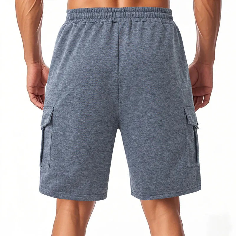 Loose grey terry fabric cargo shorts with multiple pockets on a neutral background