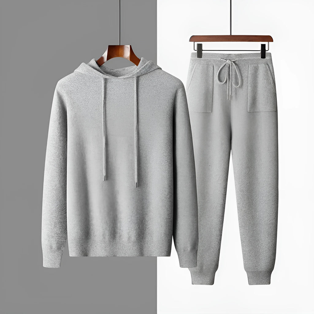 Men's dark grey cashmere hoodie and matching trousers laid out as a complete casual set.