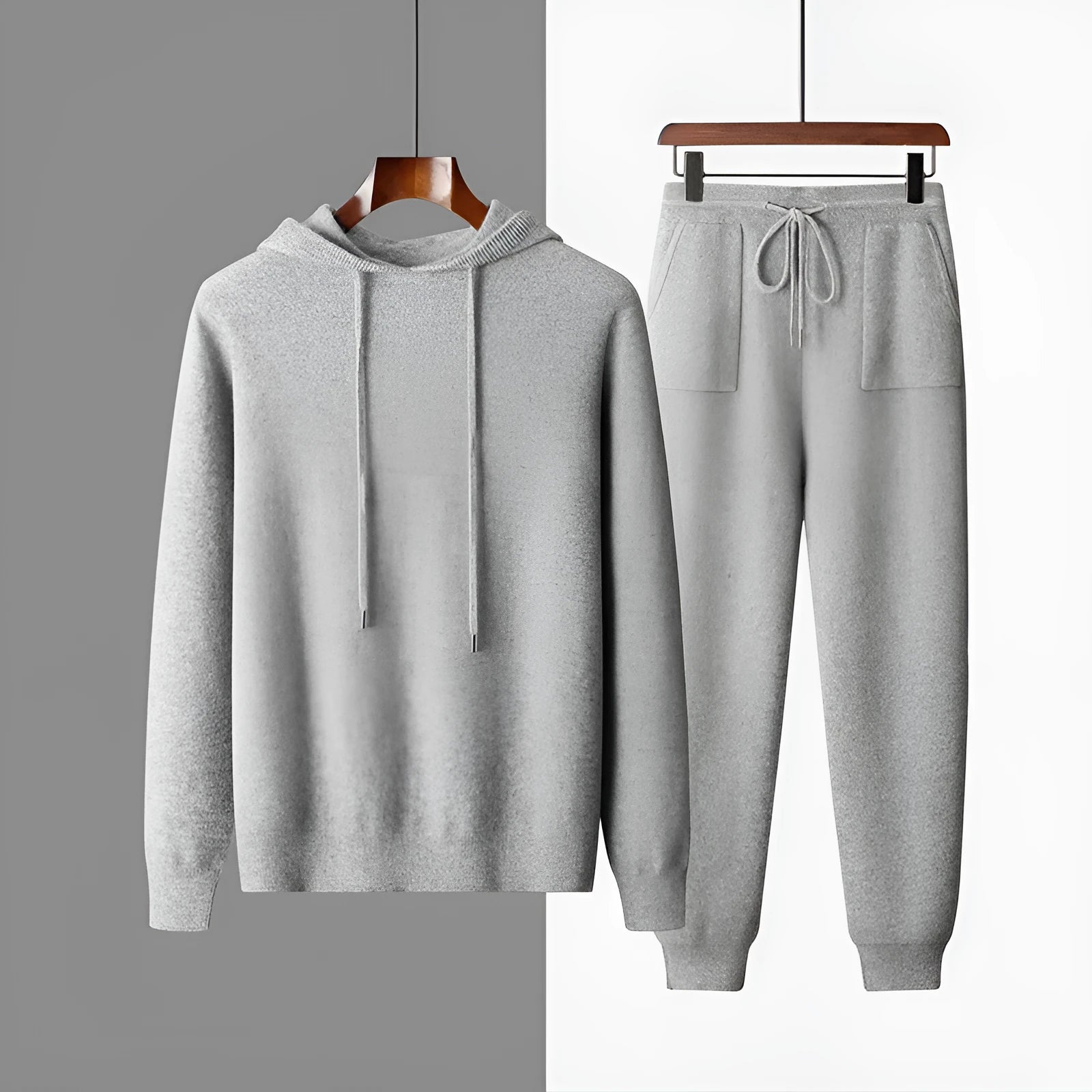 Men's dark grey cashmere hoodie and matching trousers laid out as a complete casual set.