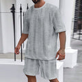 Men's wheat grain tassel knit two-piece set: grey hooded sweatshirt and matching shorts, front view on model