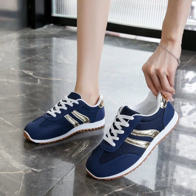 Blue women's lightweight sports shoes with cross straps and lace-up front on a flat rubber sole.
