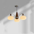 Persimmon glass chandelier with multiple chrome lampshades in a Middle Ancient style, hung from a ceiling.