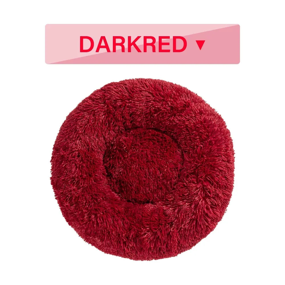 A fluffy, round donut-shaped dog bed with a raised rim in long plush fabric.