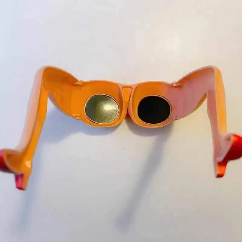 Orange plastic novelty sunglasses shaped like a pair of legs, on a white background.