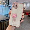 Green iPhone case with a raised 3D purple flower that acts as a spin stand, showing the built-in screen protector.