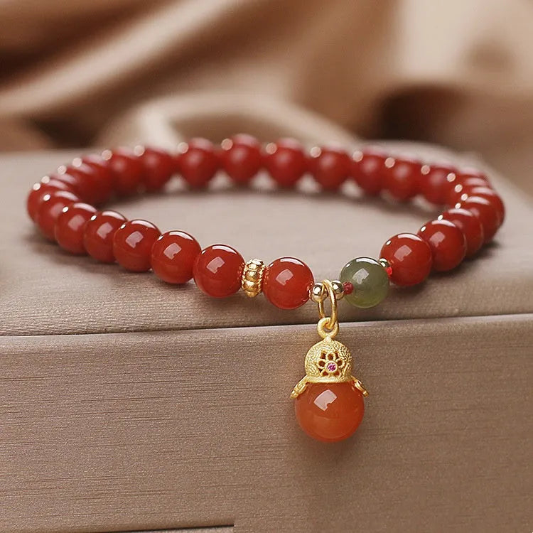 Red agate and Hetian jade bracelet with lucky beads pendant on display