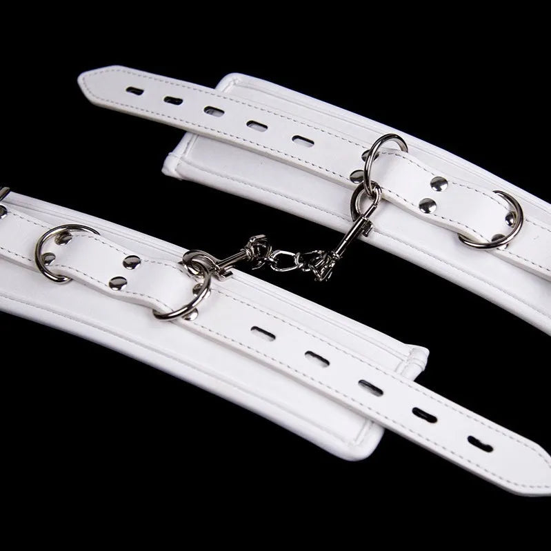 White PU sponge bondage set showing handcuffs, foot cuffs, and a neck scarf arranged together.