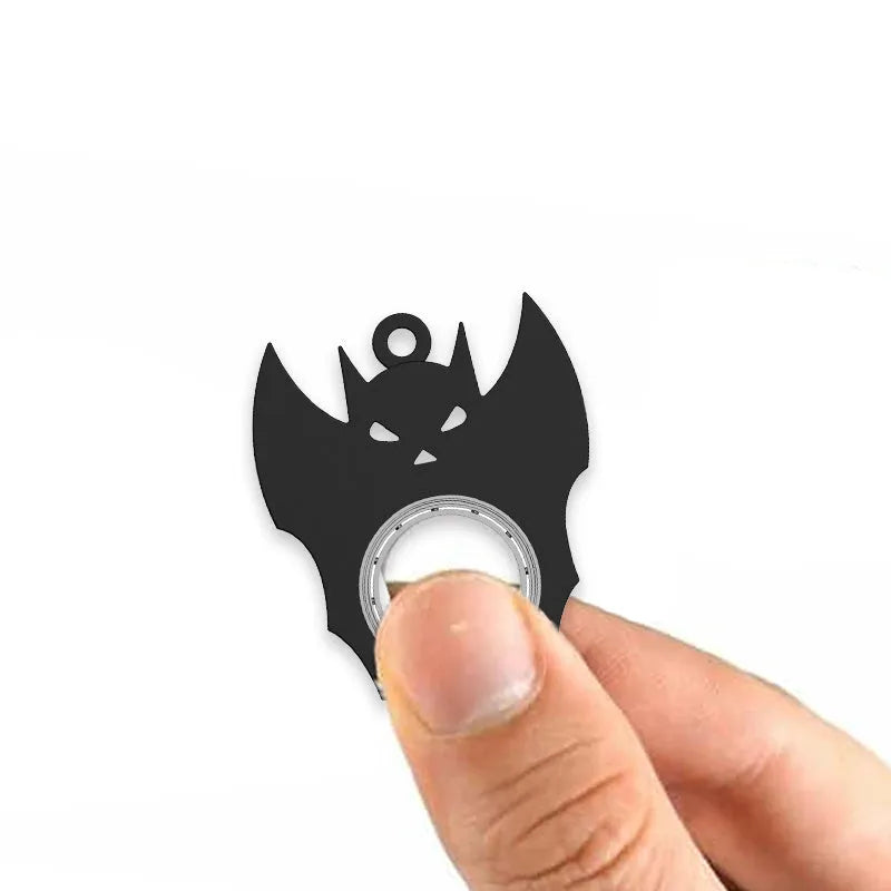 Black plastic Halloween bat demon ghost fidget spinner keychain with bottle opener on a dark background