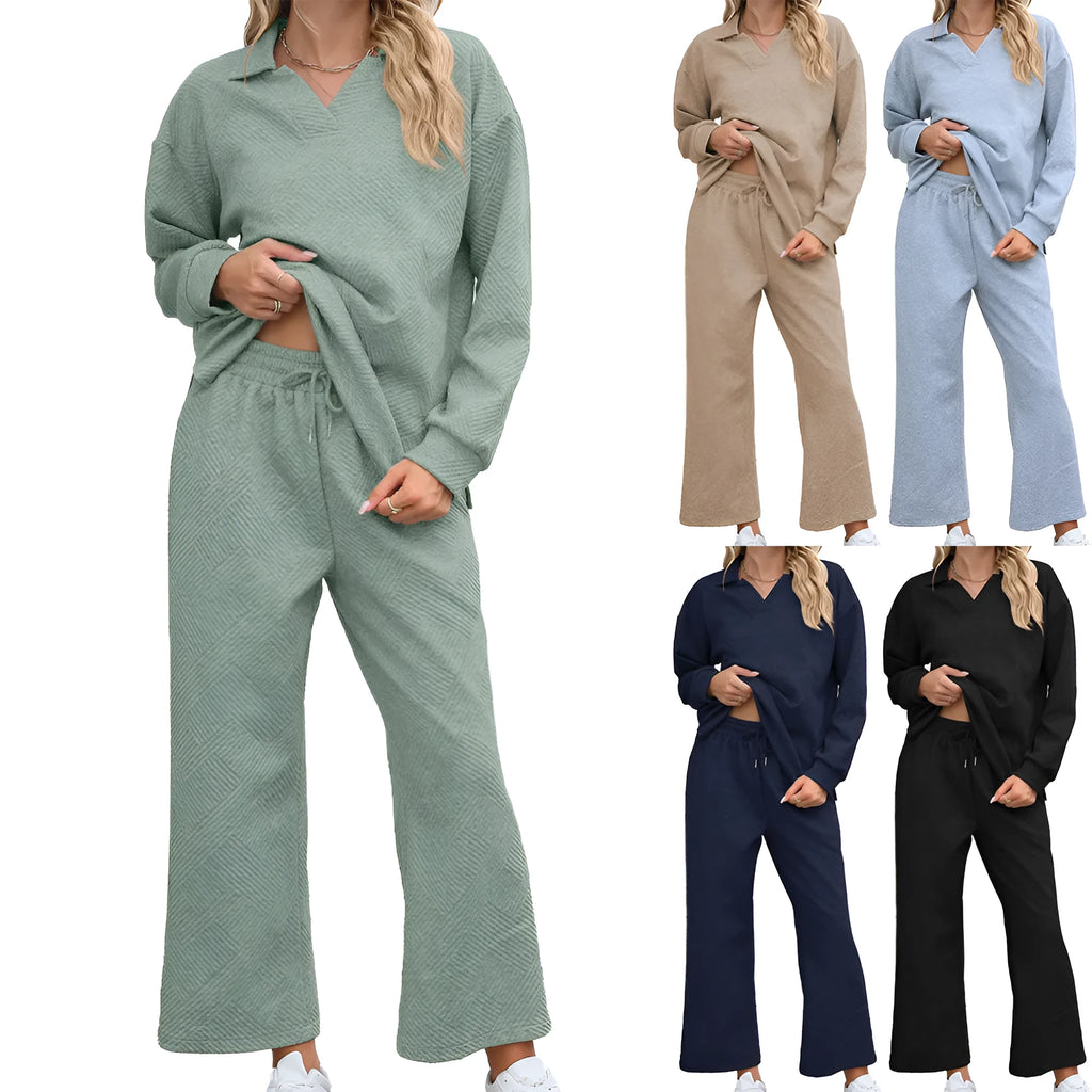 Women's black knitted rayon suit with lapel sweater and elastic waist cropped trousers on a hanger.