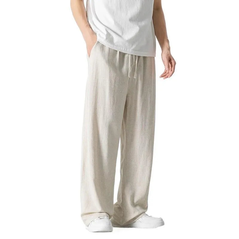 Man wearing beige straight-leg linen bamboo fibre trousers with a drawstring waist and cropped ankle length.