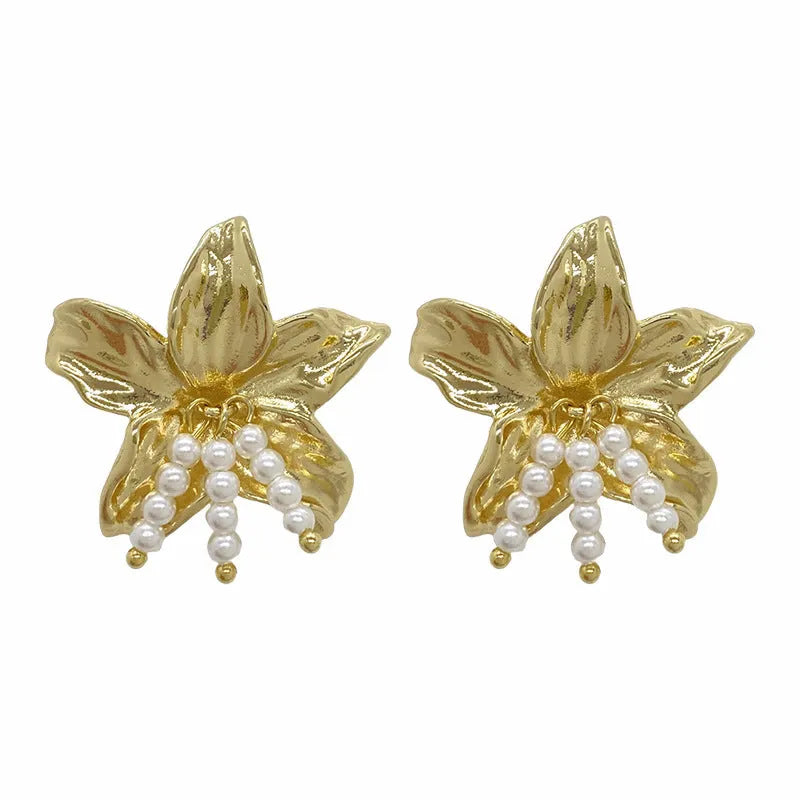 Gold H1795 metal flower earrings with an exaggerated floral design and pearl details.
