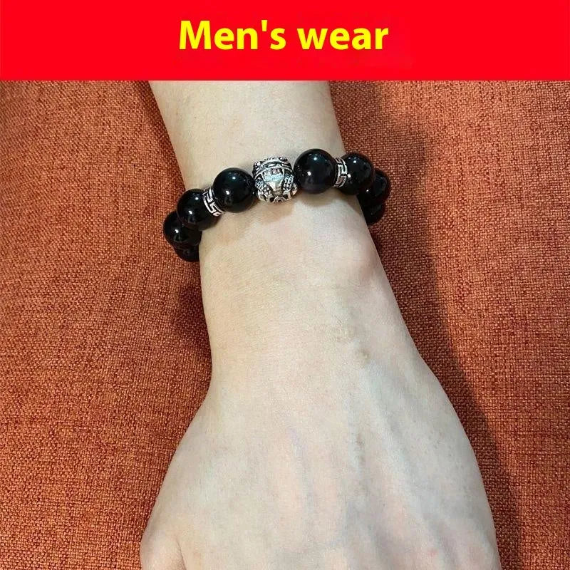 Obsidian unisex bracelet with silver detail in 10mm and 12mm bead size options on a wrist.