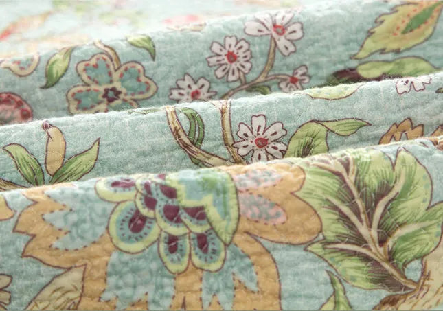 Blue American floral and bird pattern quilted cotton bedspread set on a double bed