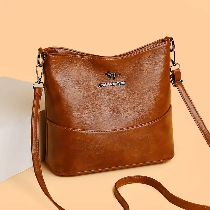 Women's soft leather bucket shoulder bag in solid colour with sewing line details and organisational pockets