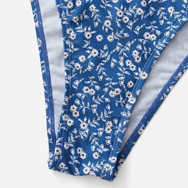 Blue women's swimsuit three-piece set featuring a top and shorts, made from polyester fabric.