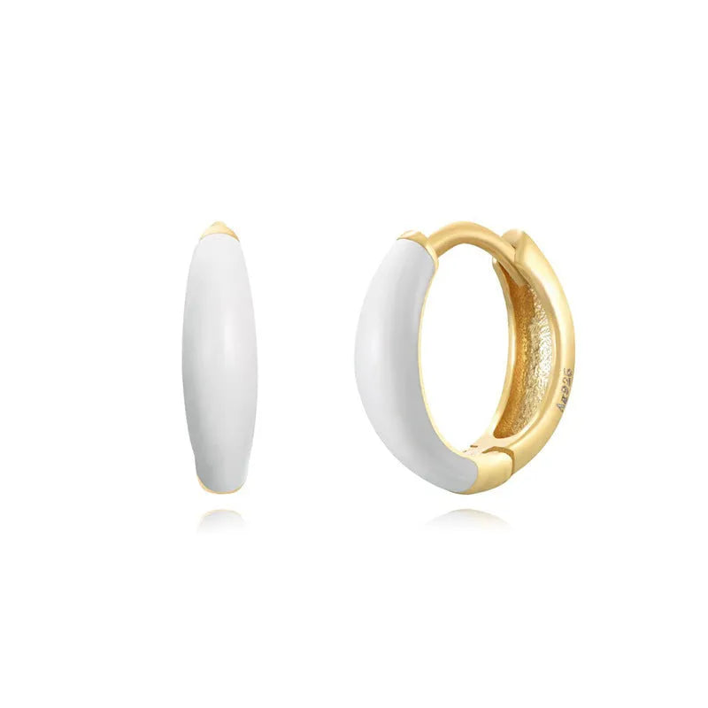 A pair of glossy light green epoxy oval earrings with a U-shaped curve and silver-coloured post on a grey background.