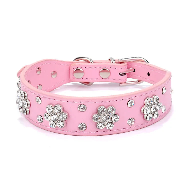 A black PU leather dog collar decorated with sparkling rhinestone flowers and metal studs, showing the adjustable eyelets and metal D-ring.