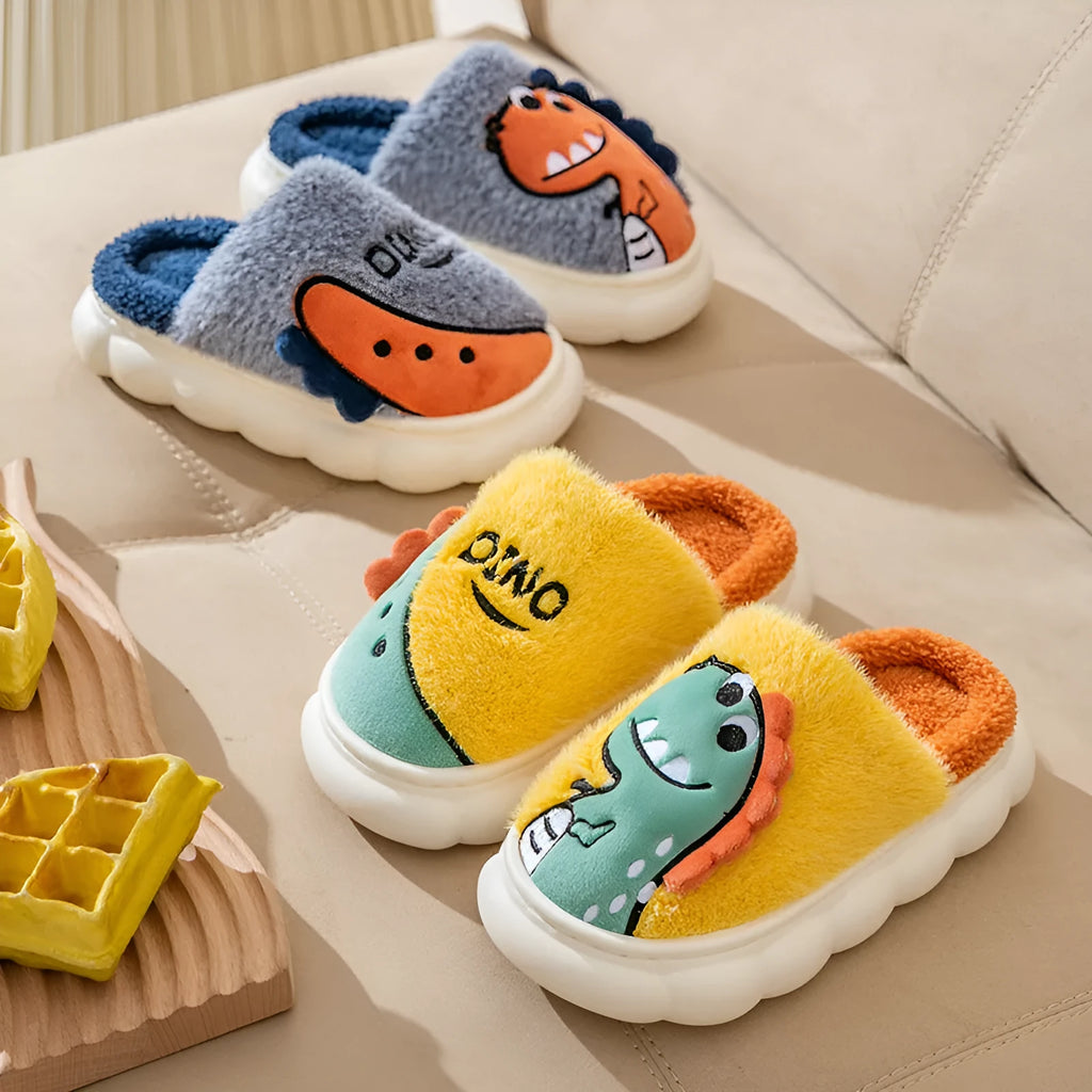 A pair of plush grey dinosaur slippers for indoor wear, showing soft cotton texture and graphic print.